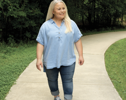 Aly, a real CRYSVITA patient, walking on a path